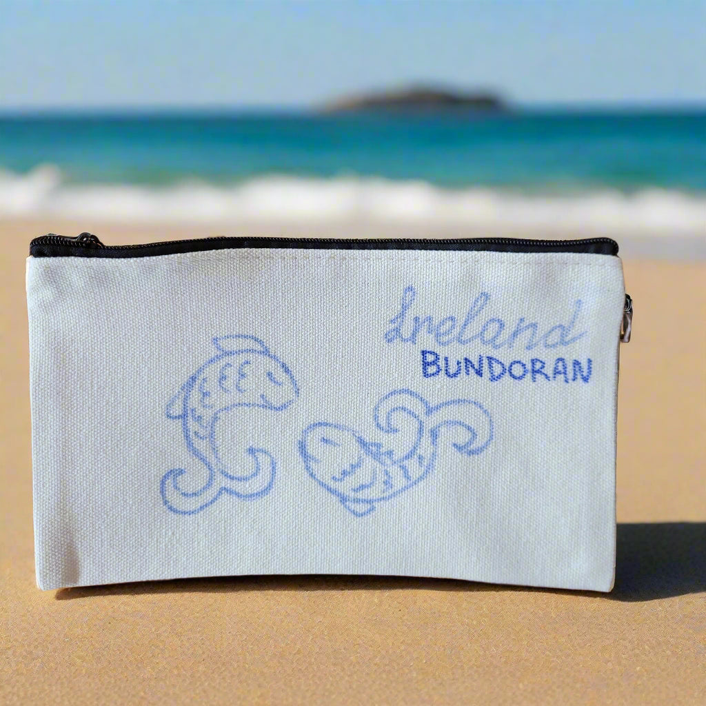 White pouch with blue text and designs on a wooden surface